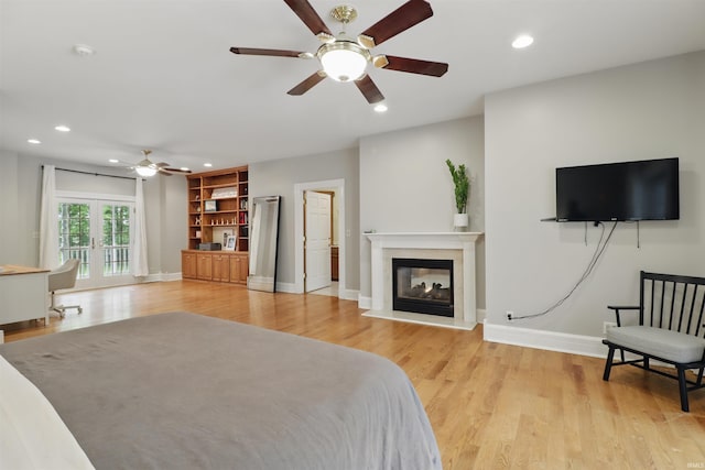 bedroom featuring a multi sided fireplace, recessed lighting, light wood-style flooring, baseboards, and a ceiling fan