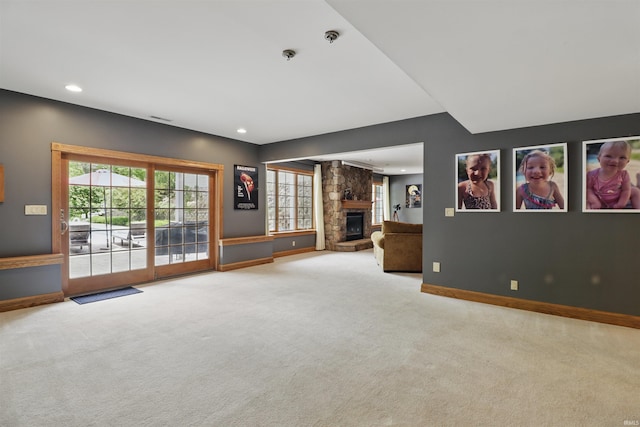 unfurnished living room featuring carpet floors, a fireplace, baseboards, and recessed lighting