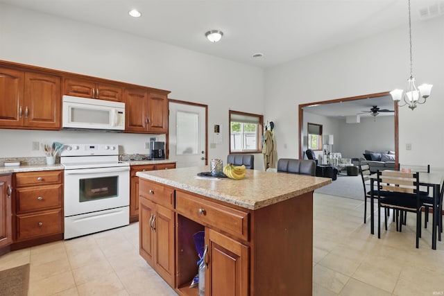 kitchen featuring white appliances, pendant lighting, a chandelier, open floor plan, and a kitchen island