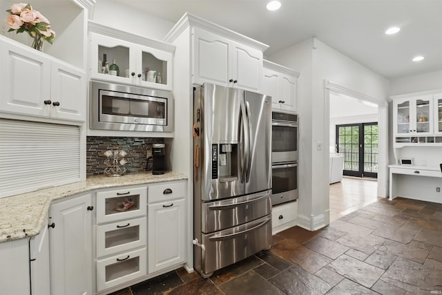 kitchen featuring appliances with stainless steel finishes, stone tile floors, recessed lighting, tasteful backsplash, and white cabinetry