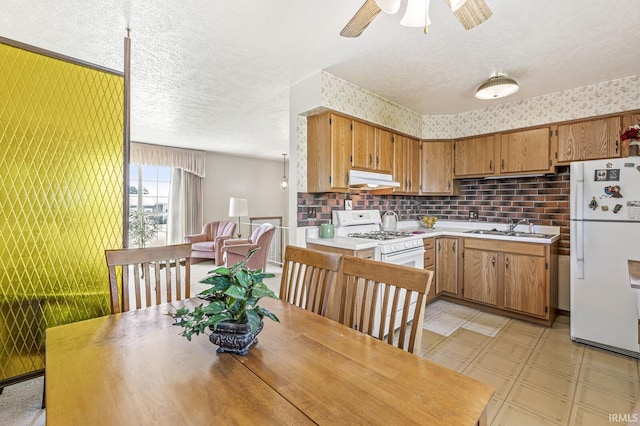 5023 Cedarwood Ln, South Bend, IN 46619 - kitchen with white appliances, a sink, light countertops, under cabinet range hood, and light flooring