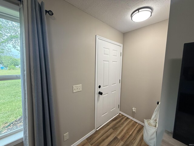 37 Ems D22A Ln, Syracuse, IN 46567 - doorway to outside featuring dark wood-type flooring, a textured ceiling, and baseboards