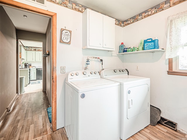 210 S E St, Oakland City, IN 47633 - laundry room featuring light wood-style flooring, separate washer and dryer, cabinet space, and baseboards