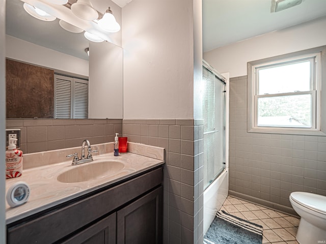210 S E St, Oakland City, IN 47633 - full bath with tile walls, tile patterned floors, toilet, vanity, and shower / bath combination with glass door