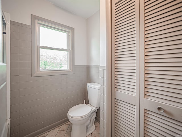 210 S E St, Oakland City, IN 47633 - bathroom with tile walls, toilet, a closet, tile patterned flooring, and wainscoting