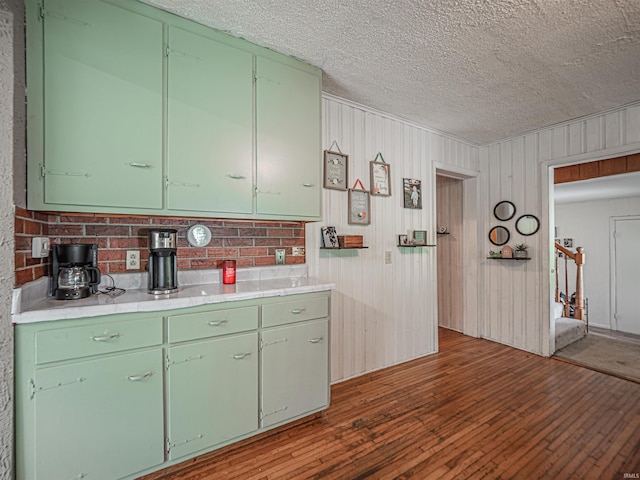 210 S E St, Oakland City, IN 47633 - kitchen with dark wood-style flooring, a textured ceiling, light countertops, and green cabinetry