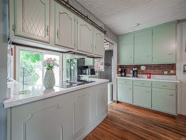 210 S E St, Oakland City, IN 47633 - kitchen featuring black electric stovetop, green cabinetry, light countertops, and wood finished floors