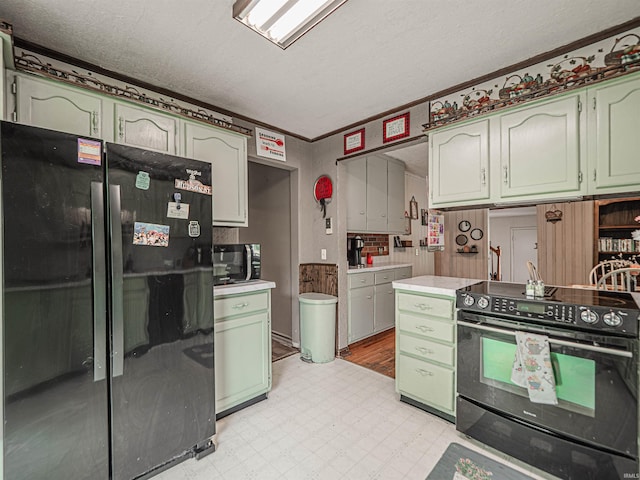 210 S E St, Oakland City, IN 47633 - kitchen featuring black appliances, light floors, green cabinetry, light countertops, and a textured ceiling