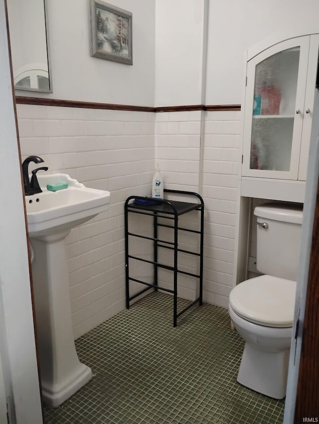 3417 Parkway S Dr, Indianapolis, IN 46201 - half bathroom with toilet, tile patterned floors, tile walls, and a wainscoted wall