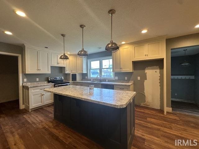 401 E Sycamore St, Converse, IN 46919 - kitchen with stainless steel electric range, dark wood-type flooring, white cabinets, a kitchen island, and recessed lighting