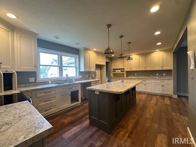 401 E Sycamore St, Converse, IN 46919 - kitchen with a sink, white cabinets, dark wood-style floors, recessed lighting, and a center island