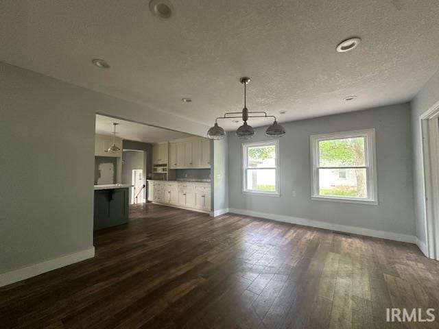 401 E Sycamore St, Converse, IN 46919 - unfurnished living room with baseboards, dark wood-style floors, and a textured ceiling