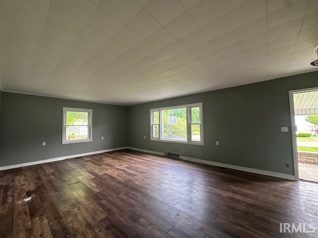 401 E Sycamore St, Converse, IN 46919 - spare room featuring healthy amount of natural light, dark wood-type flooring, and baseboards