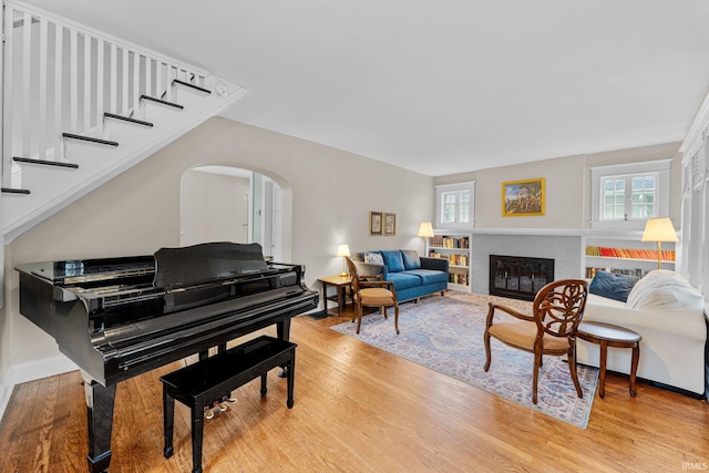 214 Tonti St, South Bend, IN 46617 - living area featuring arched walkways, light wood-style flooring, a glass covered fireplace, and baseboards