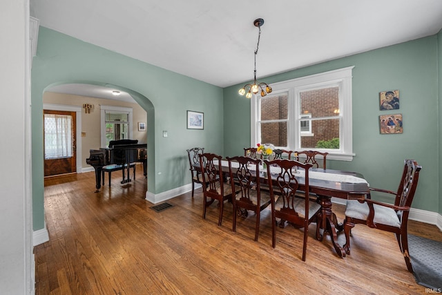 214 Tonti St, South Bend, IN 46617 - dining space featuring arched walkways, baseboards, wood-type flooring, and a chandelier