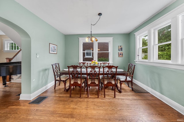 214 Tonti St, South Bend, IN 46617 - dining space with arched walkways, baseboards, light wood-style flooring, stairway, and a chandelier