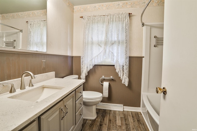 1402 Tanager Dr, Warsaw, IN 46580 - full bathroom featuring a baseboard heating unit, vanity, wood finished floors, toilet, and a wainscoted wall