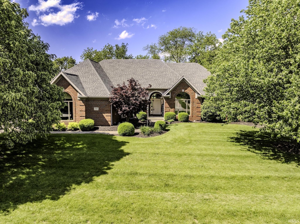 7300 W Augusta Blvd, Yorktown, IN 47396 - view of front of house with brick siding, a front yard, and a shingled roof