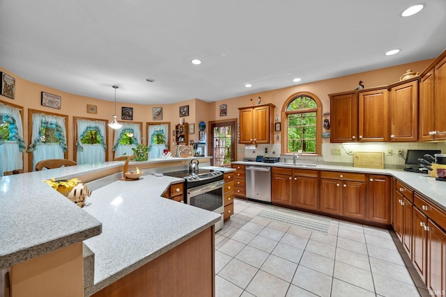 4705 Haven Ct, West Lafayette, IN 47906 - kitchen with appliances with stainless steel finishes, a sink, brown cabinets, recessed lighting, and light tile patterned flooring