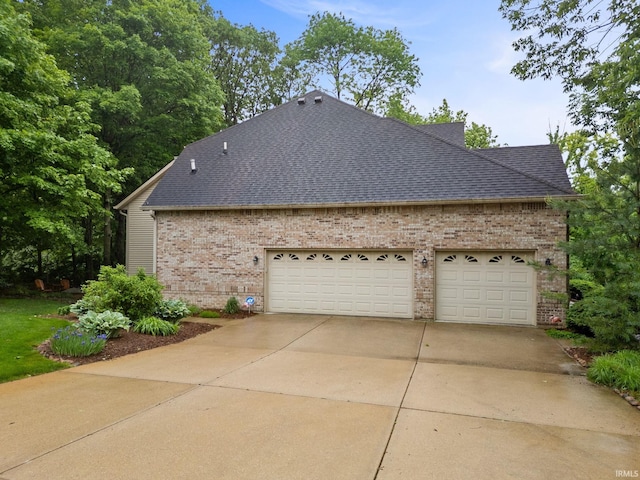 4705 Haven Ct, West Lafayette, IN 47906 - view of home's exterior featuring roof with shingles, brick siding, an attached garage, and driveway