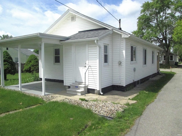 712 Hubbard St, Mishawaka, IN 46544 - view of property exterior with entry steps, roof with shingles, a carport, and a patio area