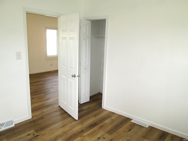 712 Hubbard St, Mishawaka, IN 46544 - unfurnished bedroom featuring baseboards, dark wood-style floors, and a closet