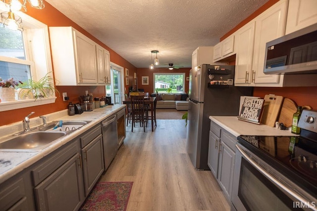 509 N Mckenzie St, Muncie, IN 47304 - kitchen with appliances with stainless steel finishes, a sink, gray cabinets, a textured ceiling, and light countertops