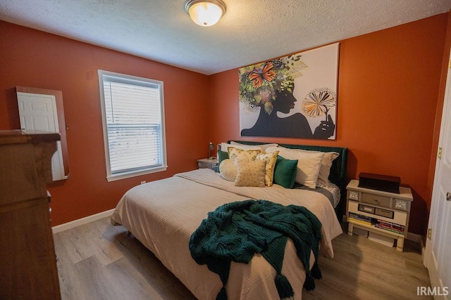 509 N Mckenzie St, Muncie, IN 47304 - bedroom featuring wood finished floors, a textured ceiling, and baseboards
