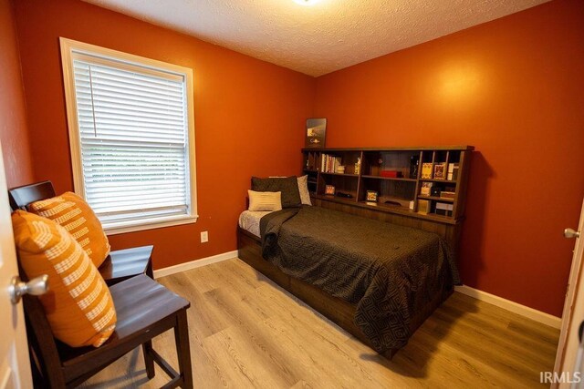 509 N Mckenzie St, Muncie, IN 47304 - bedroom featuring wood finished floors, baseboards, and a textured ceiling