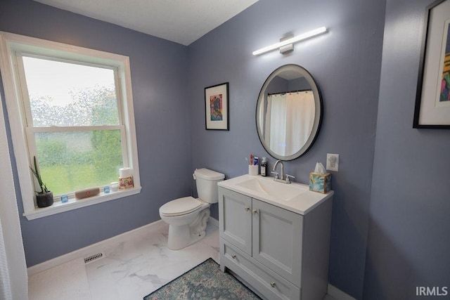 509 N Mckenzie St, Muncie, IN 47304 - bathroom with toilet, vanity, baseboards, and marble look tile flooring