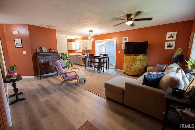 509 N Mckenzie St, Muncie, IN 47304 - living area featuring a ceiling fan, light wood-type flooring, a textured ceiling, and baseboards