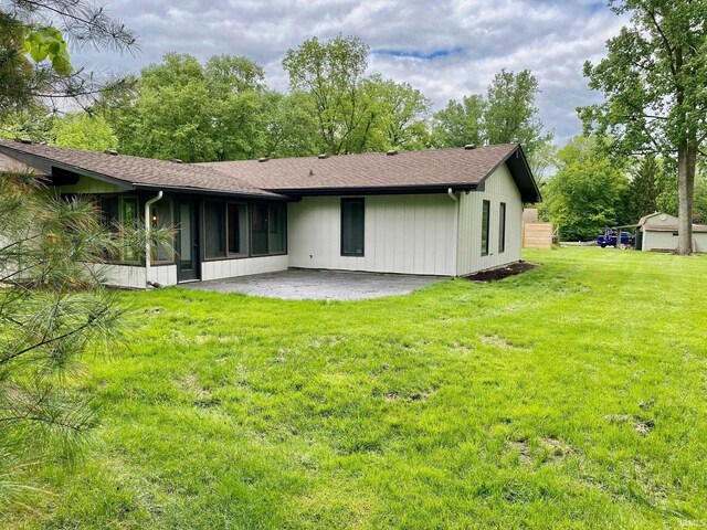 4605 Merriam Park Dr, Fort Wayne, IN 46816 - rear view of house featuring a patio, a lawn, a shingled roof, and a sunroom