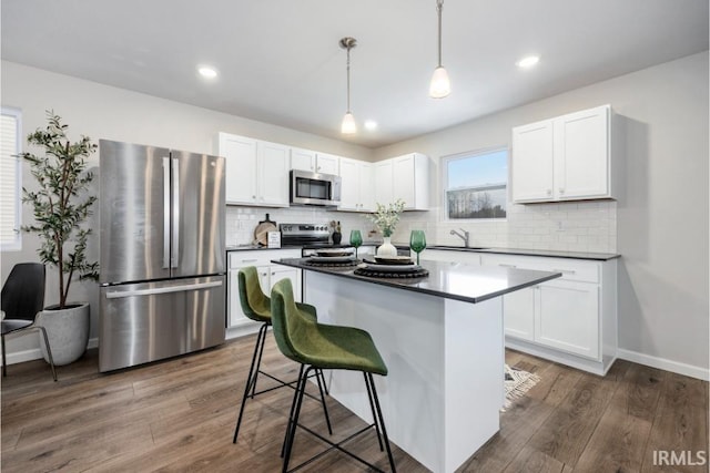 2200 Miami Trl, Huntington, IN 46750 - kitchen featuring appliances with stainless steel finishes, dark countertops, a kitchen breakfast bar, white cabinetry, and recessed lighting