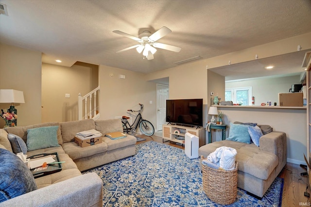 3491 S Oaklawn Cir, Bloomington, IN 47401 - living area featuring wood finished floors, ceiling fan, stairway, recessed lighting, and a textured ceiling