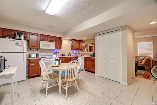 3491 S Oaklawn Cir, Bloomington, IN 47401 - kitchen featuring white appliances, light tile patterned floors, light countertops, a textured ceiling, and recessed lighting