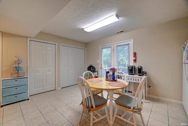 3491 S Oaklawn Cir, Bloomington, IN 47401 - dining room featuring light tile patterned floors, a textured ceiling, and baseboards