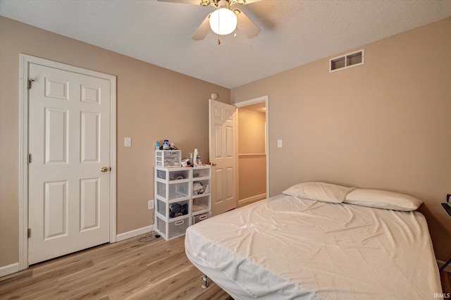 3425 S Oaklawn Cir, Bloomington, IN 47401 - bedroom featuring light wood-style flooring, ceiling fan, baseboards, and a textured ceiling