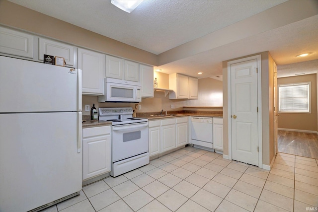 3425 S Oaklawn Cir, Bloomington, IN 47401 - kitchen featuring white appliances, a sink, white cabinets, a textured ceiling, and light tile patterned floors