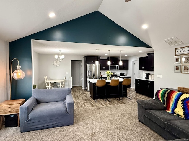 310 Main St, Lagro, IN 46941 - living area featuring high vaulted ceiling, light wood-style floors, a chandelier, and recessed lighting