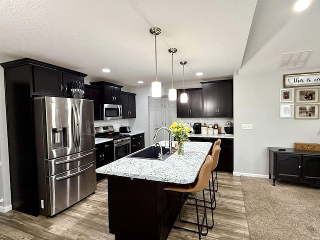 310 Main St, Lagro, IN 46941 - kitchen with appliances with stainless steel finishes, a sink, decorative backsplash, an island with sink, and recessed lighting