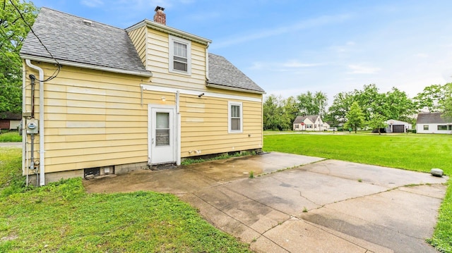 5916 S Harrison St, Fort Wayne, IN 46807 - rear view of property featuring a chimney, a shingled roof, a yard, and a patio