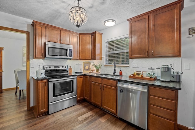 821 Lagrange St, West Lafayette, IN 47906 - kitchen featuring appliances with stainless steel finishes, a sink, tasteful backsplash, dark wood finished floors, and a textured ceiling
