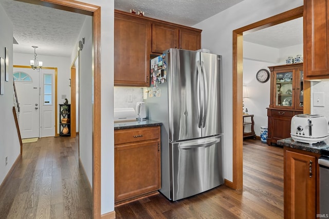 821 Lagrange St, West Lafayette, IN 47906 - kitchen featuring freestanding refrigerator, a textured ceiling, dark wood-style floors, a chandelier, and dark stone counters