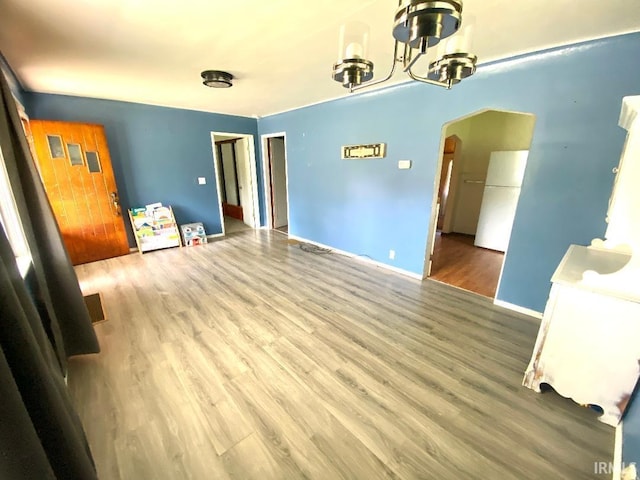 589 2nd St NW, Linton, IN 47441 - unfurnished room with arched walkways, a chandelier, wood finished floors, and baseboards