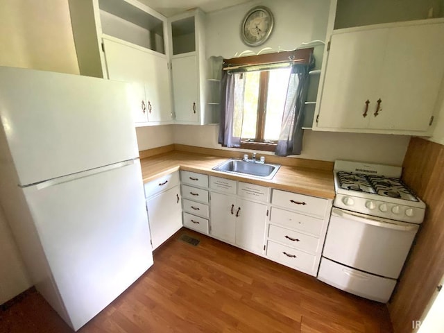 589 2nd St NW, Linton, IN 47441 - kitchen with white appliances, a sink, light countertops, and wood finished floors