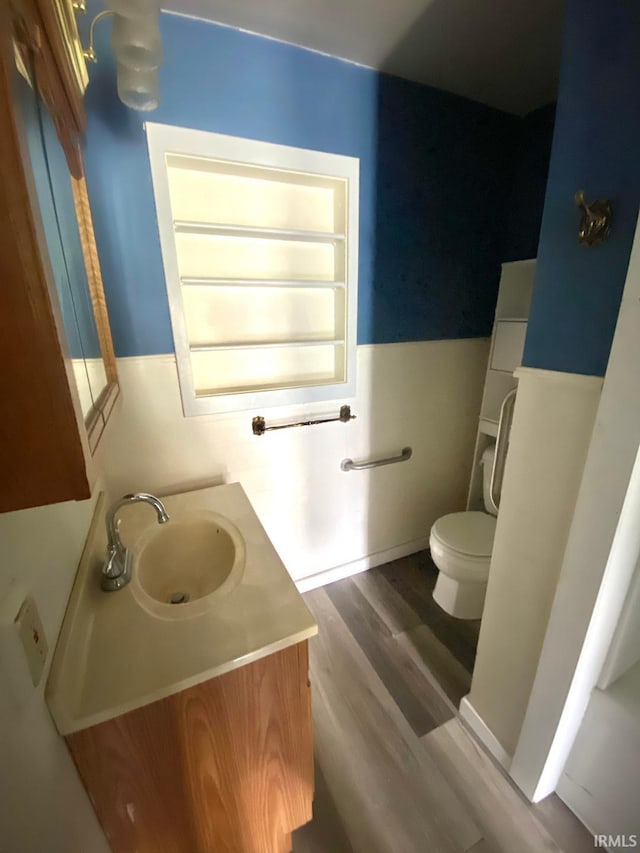 589 2nd St NW, Linton, IN 47441 - half bath featuring toilet, vanity, and wood finished floors