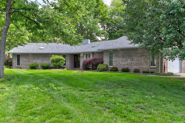 1124 S Snow Ball Ln W, Santa Claus, IN 47579 - ranch-style house with an attached garage, brick siding, a front lawn, and a chimney