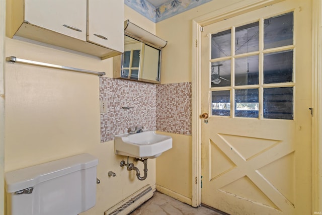 1725 W Saxon Dr, Marion, IN 46952 - half bath with a baseboard heating unit, toilet, a sink, and tile walls