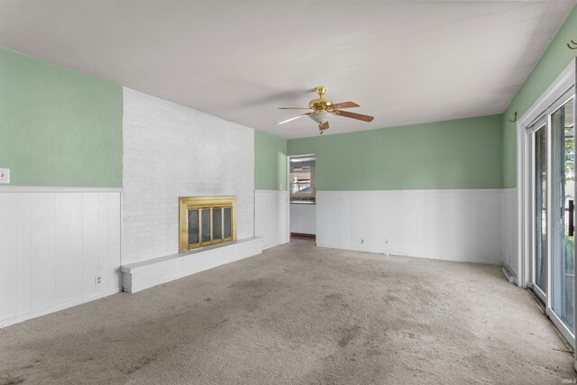 1725 W Saxon Dr, Marion, IN 46952 - unfurnished living room featuring a wainscoted wall, a fireplace, carpet flooring, and ceiling fan
