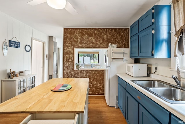 96 Ems B61I Ln, Warsaw, IN 46582 - kitchen featuring blue cabinets, white microwave, a sink, wood finished floors, and wooden counters